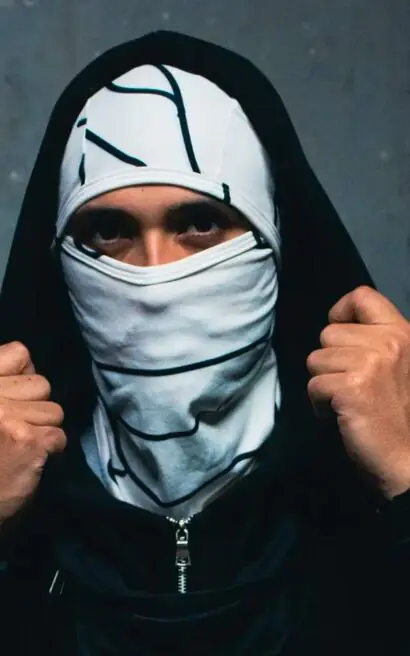Máscara y sudadera negra, estilo urbano y deportivo, en fondo gris oscuro.