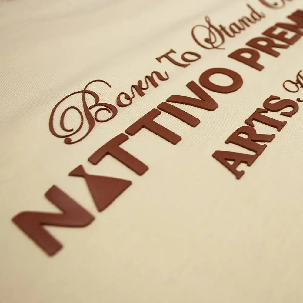 Detalle de la etiqueta Nattivo en tela arena sand, resaltando el logo y el estilo de la marca.